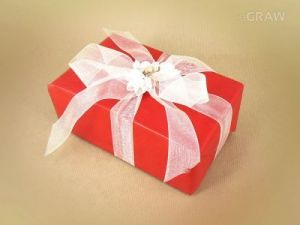 Pakowanie na prezent - biała wstążka z kwiatkami, całość zapakowane w ozdobny papier koloru czerwone