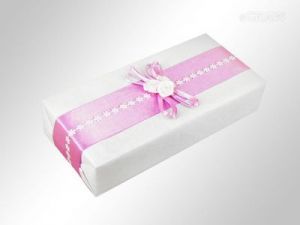 Pakowanie na prezent - różowa tasiemka z kwiatkami, całość zdobiona wstążką i różyczkami